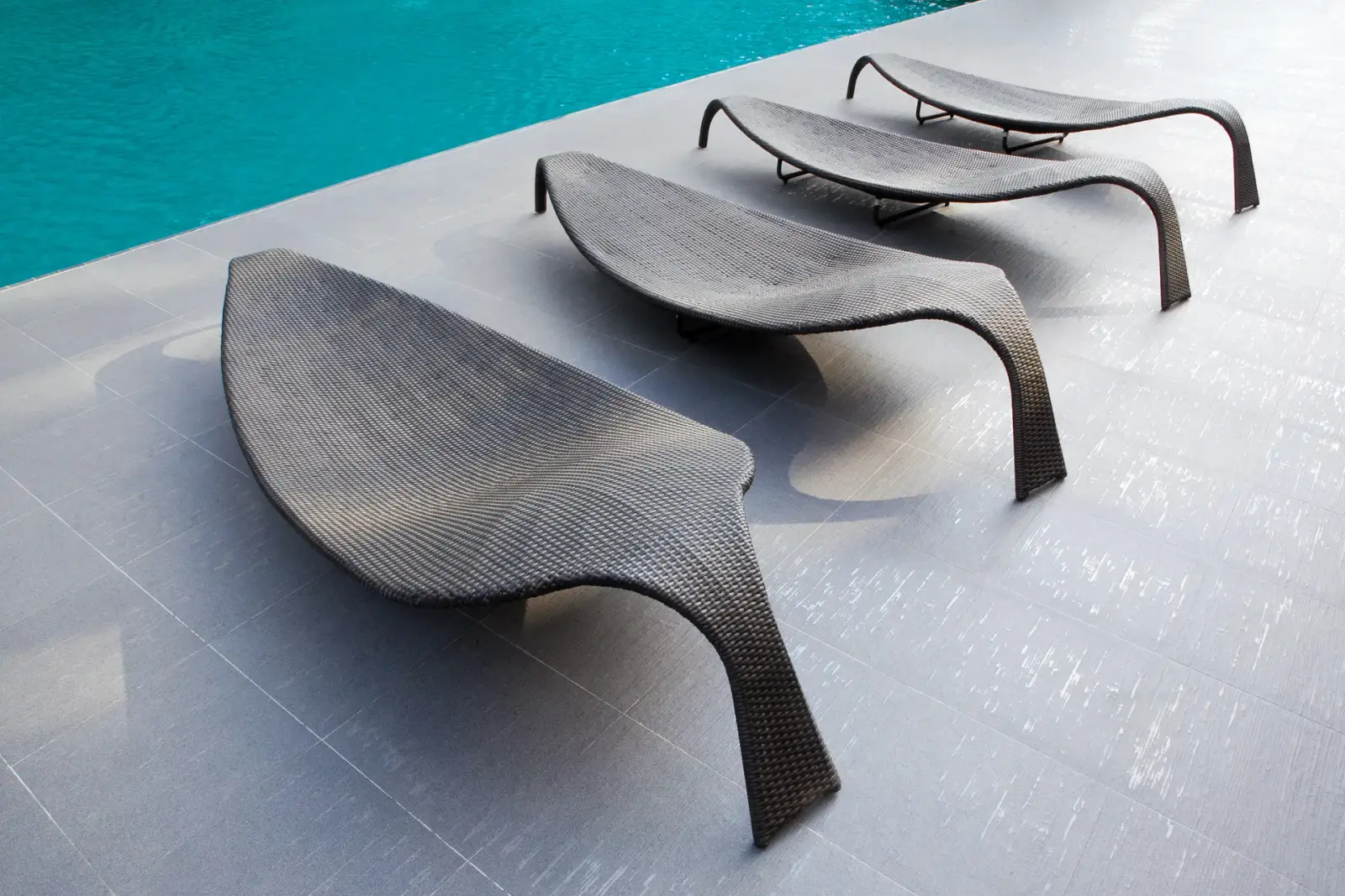 Woven loungers beside a pool